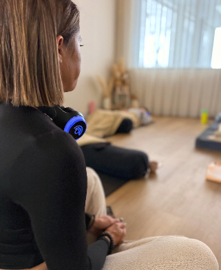 Roz guiding a woman wearing 9D immersive audio headphones during a breathwork circle
