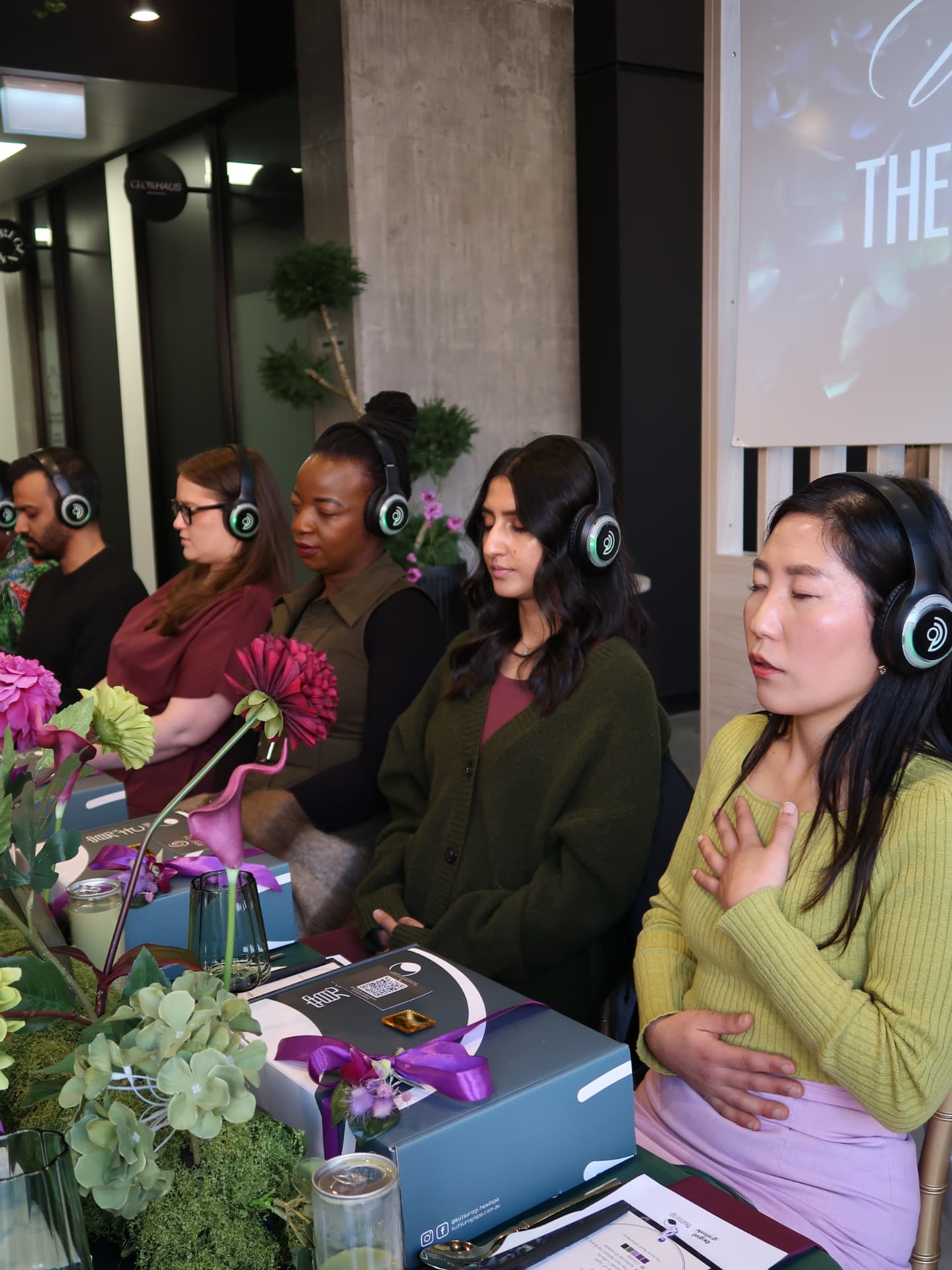 Team members seated with eyes closed during a guided corporate breathwork session