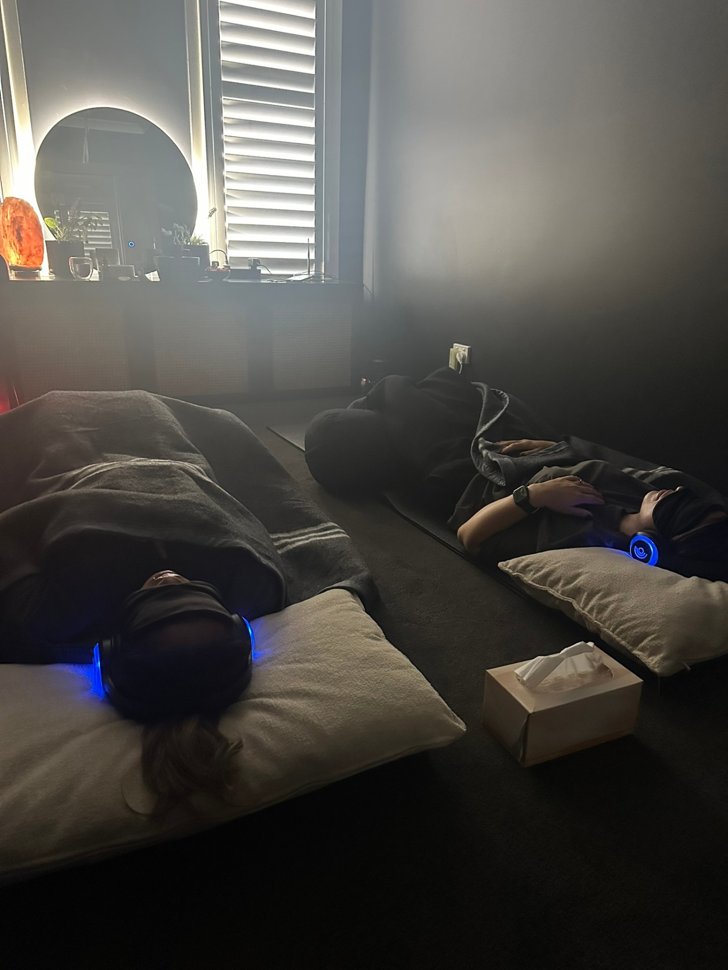 Calm studio space with two clients resting after breathwork
